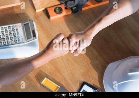 Vista superiore di architettura e di ingegneria punch mano sul tavolo di lavoro con strumenti di costruzione dopo la finitura deal, contratto di segno e di piallatura di successo Foto Stock