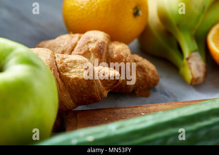 Ristorante e bar Colazione La colazione è servita con croissant, le arance, le mele e le fette di pane bianco sul tavolo da cucina, vista dall'alto, close-up, il fuoco selettivo. Perfetto sna vegetariano Foto Stock