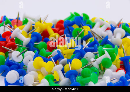 Pila di plastica bacheca spingere i pin su sfondo bianco Foto Stock