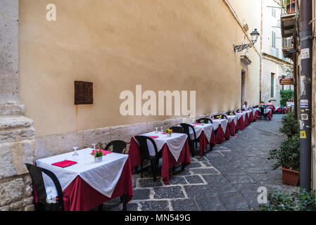 Siracusa, Italia - Agosto 17, 2017: terrazzo di un ristorante bar con persone intorno su una stradina del centro storico di Siracusa, Sicilia, Italia Foto Stock