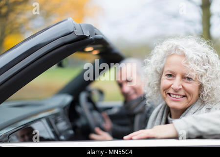 Ritratto sorridente coppia senior nel convertibile Foto Stock