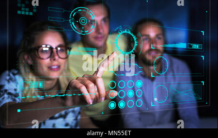 Programmatori di computer esaminando i dati sull'ologramma futuristico Foto Stock