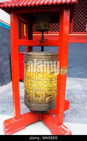 Un ornato cinese ruota di preghiera presso il centro storico di Tempio di Yonghegong a Pechino in Cina. La ruota stessa è la filatura. Foto Stock