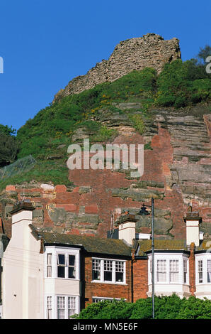 Terreced case sotto West Hill in Hastings, East Sussex Regno Unito, con le rovine del castello di Hastings sopra. Foto Stock