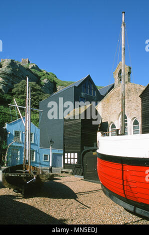 La Stade a Hastings, East Sussex, sulla costa sud, con barche e net capannoni e East Hill nel backgroundd Foto Stock