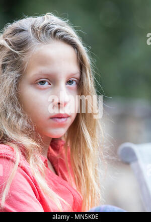 Dieci anni dai capelli biondi ragazza . Ritratto dal petto fino, guardando al lato. Foto Stock