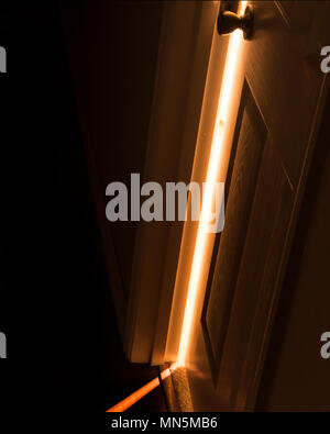 Luce brilla attraverso una porta parzialmente aperta. Foto Stock