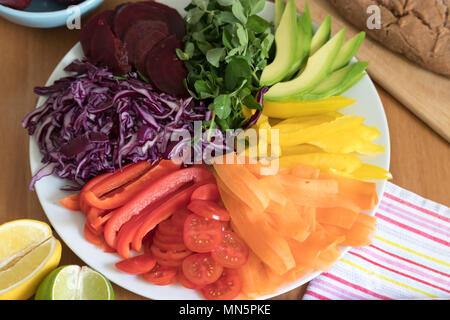 Insalata arcobaleno con fresco cotto al forno, senza glutine pane di grano saraceno. Questo pasto sano include avocado, peperoni, pomodori carote, barbabietole, cavolo & peashoots. Foto Stock