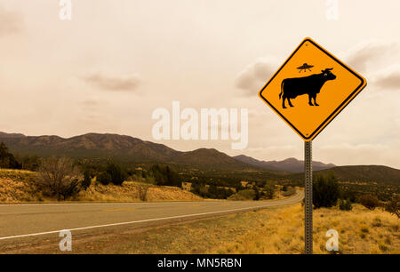 Funny Cow Alien Abduction cartello stradale lungo il sentiero di turchese, Route 66 Scenic Byway, in primavera tra Santa Fe e Albuquerque, Nuovo Messico. Foto Stock