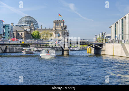 Berlino, Germania - 22 Aprile 2018: Fiume Spree con imbarcazioni turistiche, il ponte Marschallbruecke, il Parlamento vecchio edificio Reichstag e il nuovo parli Foto Stock