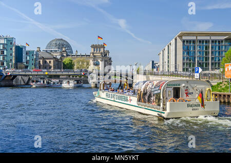 Berlino, Germania - 22 Aprile 2018: Fiume Spree con imbarcazioni turistiche, il ponte Marschallbruecke, il Parlamento vecchio edificio Reichstag e il nuovo parli Foto Stock