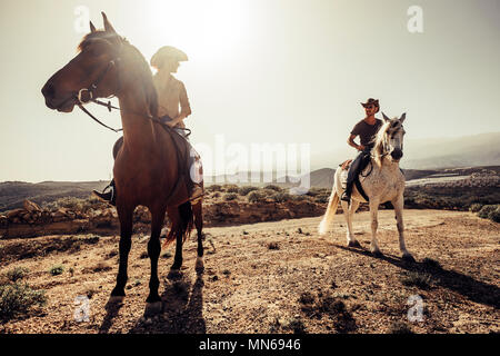 Coppia di cavalli e cowboy maschio e femmina ride free nella natura sulle montagne di Tenerife. Uno stile di vita alternativo e le opere o le attività per il tempo libero Foto Stock