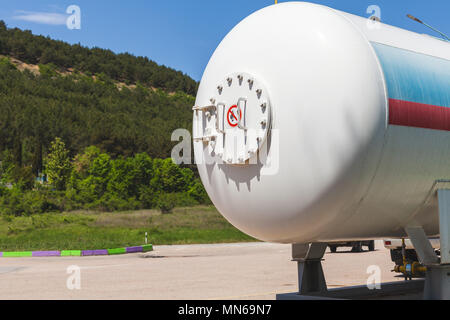 Serbatoio bianco con gas di petrolio liquefatto sorge su una stazione di gas Foto Stock