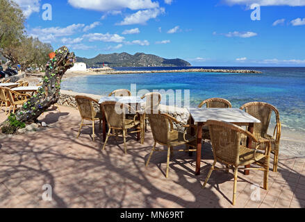 Il rattan Sedie e tavoli e al di fuori dei bar, Cala Millor Maiorca Foto Stock