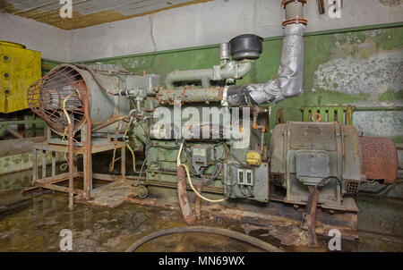 Un vecchie e arrugginite generatore diesel per fornire elettricità in un rifugio sotterraneo in caso di emergenza. Foto Stock