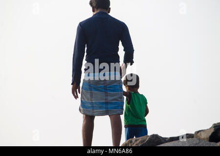 Padre e figlio piccolo camminando sulle rocce casualmente Foto Stock