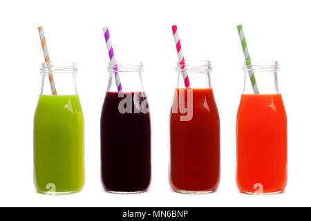 Quattro bottiglie di succo di verdura, verdi, barbabietole, il pomodoro e la carota, isolato su uno sfondo bianco Foto Stock