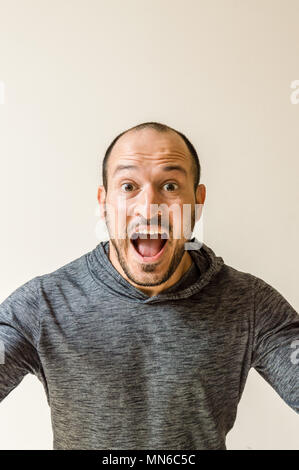 Giovane uomo che agisce sorpreso isolato su un muro bianco Foto Stock