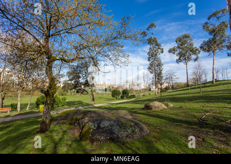 Grande verde prato con alberi e massi di granito nel Parque da Devesa Urban City Park. Vila Nova de Famalicao, Portogallo Foto Stock