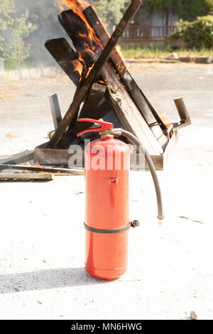 Base di lotta antincendio e di evacuazione esercitazione antincendio con formazione di simulazione per la sicurezza in un condominio o in fabbrica, dettaglio di un estintore Foto Stock