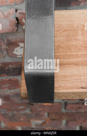 Ripiano in legno e metallo appeso a una parete in mattoni in stile loft Foto Stock