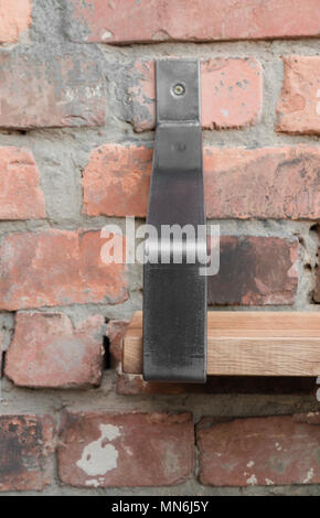 Ripiano in legno e metallo appeso a una parete in mattoni in stile loft Foto Stock