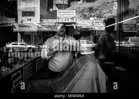 Rasatura barbiere di un cliente nella sua barberia Foto Stock