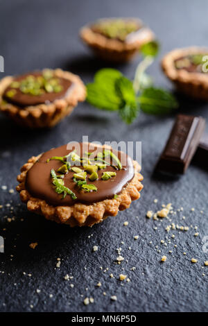 Tortine al cioccolato ripieno, pistacchio e la buccia del lime topping Foto Stock