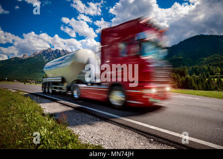 Carrello carburante precipita l'autostrada sullo sfondo delle Alpi. Carrello Car in motion blur. Foto Stock