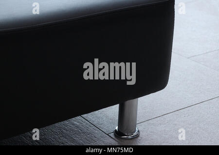 Massiccio divano in pelle con gambe cromate vicino a Foto Stock