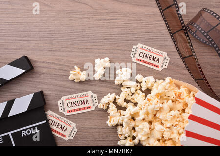 Le attrezzature e gli elementi del cinema sul tavolo di legno closeup. Concetto di guardare film. Composizione orizzontale. Vista dall'alto. Foto Stock