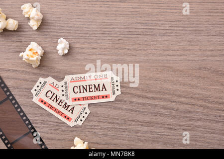 Le attrezzature e gli elementi di dettaglio del cinema sul tavolo di legno. Concetto di guardare film. Composizione orizzontale. Vista dall'alto. Foto Stock