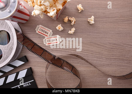 Attrezzature e elementi di cinema su un tavolo di legno. Concetto di guardare film. Composizione orizzontale. Vista dall'alto. Foto Stock