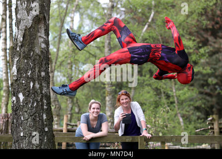 Luca Aquilina come Deadpool dimostra le sue abilità di parkour a Blair Drummond Safari Park in Scozia, come Sharon McGinty e Liz Gunn (destra) guarda su. Sono in corso preparativi per la loro super eroe sul weekend del 26 e 27 maggio. Foto Stock