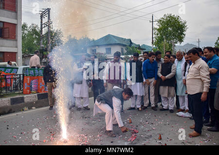 15 maggio 2018 - Srinagar, Jammu e Kashmir India - BJP lavoratori visto guardando il firecrakers come si celebra il partito votare portano a Srinagar il martedì. Il Bharatiya Janata Party (BJP), Kashmir, unità di oggi scoppiare petardi e dolciumi distribuiti al di fuori del suo partito ufficio qui a celebrare la derivazione elettorale in voti in Karnataka elezioni. Credito: Abbas Idrees SOPA/images/ZUMA filo/Alamy Live News Foto Stock