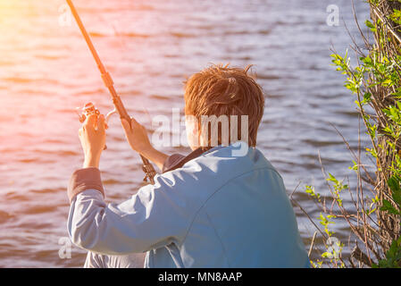 Ragazza con canna da pesca la pesca nel bacino del lago Foto Stock