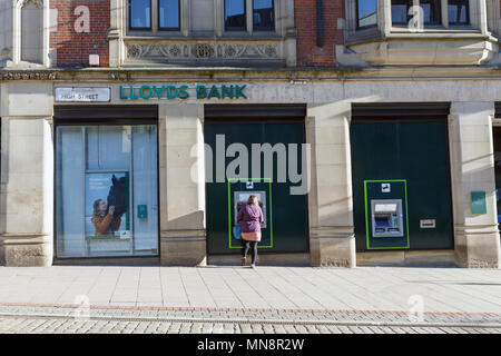 Una donna con un ATM in Banca di Lloyds nel Regno Unito. Foto Stock