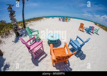 Obiettivo Fisheye vista delle sedie colorate sul Golfo del Messico spiaggia presso il South Beach Bar & Grill in Boca Grande su Gasparilla Island Florida Foto Stock