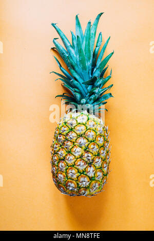 Ananas isolata contro uno sfondo arancione Foto Stock
