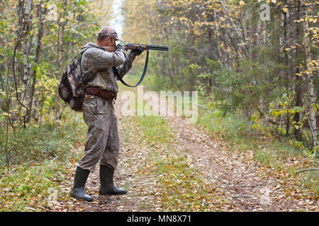 Hunter prendendo mirano da un fucile da caccia di quaglie Foto Stock