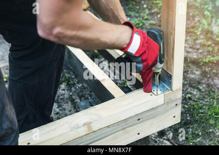 Tettoia in legno da costruzione - uomo avvitamento giunto angolare tutore Foto Stock