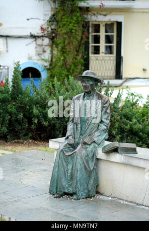 Un vecchio uomo con un libro si siede su un banco di lavoro. Statua che si trova nella zona vecchia di Ibiza. Isole Baleari. Spagna Foto Stock