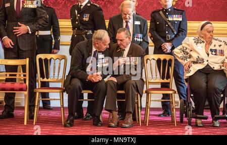 George Cross destinatario Alf Lowe (sinistra) guarda le medaglie della Victoria Cross destinatario Keith Payne durante un tea party al Clarence House di Londra per i membri della Victoria Cross e la Croce di San Giorgio Associazione. Foto Stock