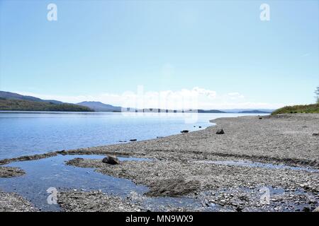 Bella Loch Lomond Scozia, Regno Unito in una limpida giornata di sole che mostra acqua e montagne in una vista mozzafiato. Una popolare attrazione turistica e vacanze Foto Stock