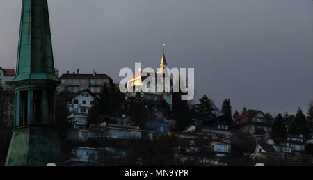 La chiesa il campanile e case su una collina nella luce del tramonto Foto Stock