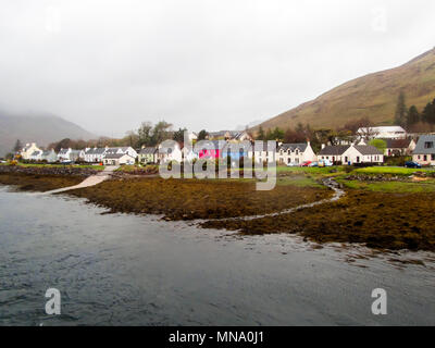 Scena scozzese sotto la pioggia e nebbia. La piccola e bella ex villaggio di pescatori di Dornie sulle rive di Loch Alsh e Loch Duich con la sua colorata h Foto Stock