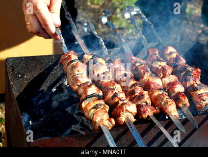 Per la cottura di spiedini sulla natura. Girare a mano il perno sul grill. Foto Stock