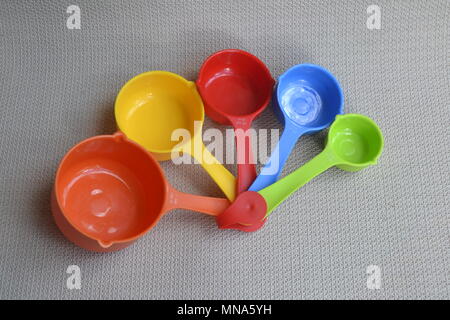 Nested arcobaleno colorato cucina tazze di misura cucchiai utensili colorati Foto Stock