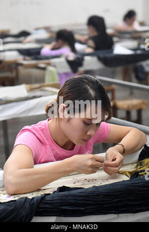 Jingxi cinese di Guangxi Zhuang Regione autonoma. 15 Maggio, 2018. Un lavoratore di sesso femminile ricama a una società di ricamo in Jingxi City, a sud della Cina di Guangxi Zhuang Regione autonoma, 15 maggio 2018. Con lo sviluppo del settore artigianale, donne ottenere impiegati vicino alle loro case in città Jingxi. Credito: Lu Boan/Xinhua/Alamy Live News Foto Stock