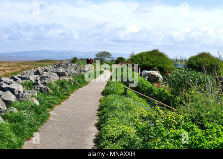 Coppia di mezza età a piedi lungo il sentiero sul fiume Wyre estuary al Knott fine,lancashire, Regno Unito Foto Stock